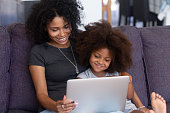 Mother and daughter with laptop smiling