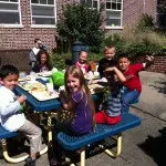 Jordan, Saurab, Victoria, Cayleigh, Aidan K., Angel, Wilfredo, and Alexis crowd around the picnic table